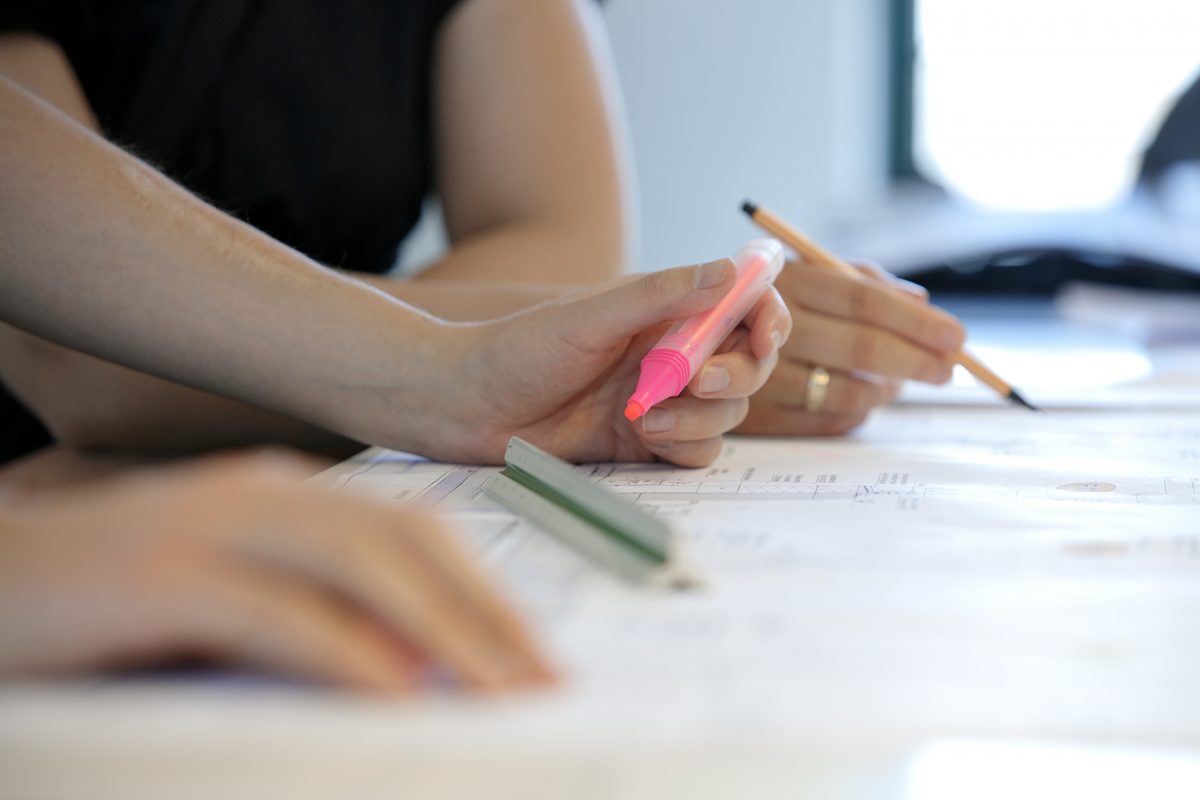 Hand markiert Bauzeichnung mit pinkem Textmarker.