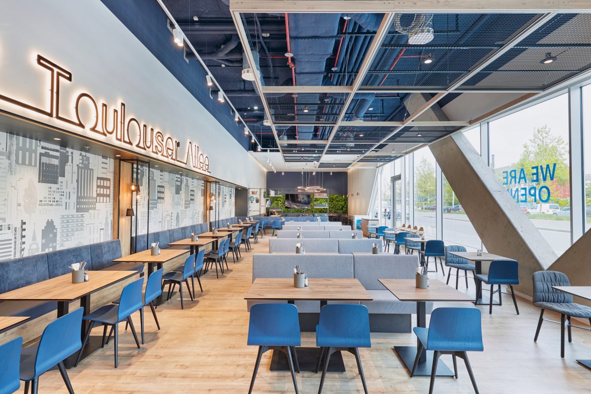 Modernes Hotelrestaurant mit großzügigen Fensterfronten und stilvollem Interieur.