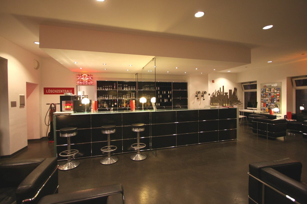 Moderne Hotelbar mit schwarzen Möbeln, Glastheke und gemütlicher Lounge.