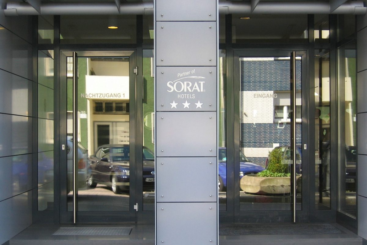 Hoteleingang mit Glasfront und Logo „Partner of SORAT Hotels“.