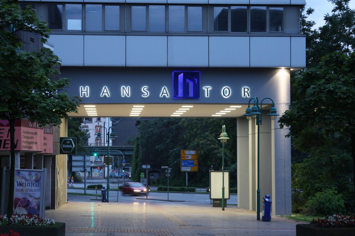 Torpassage mit beleuchtetem Schriftzug „HANSATOR“ in der Abenddämmerung.