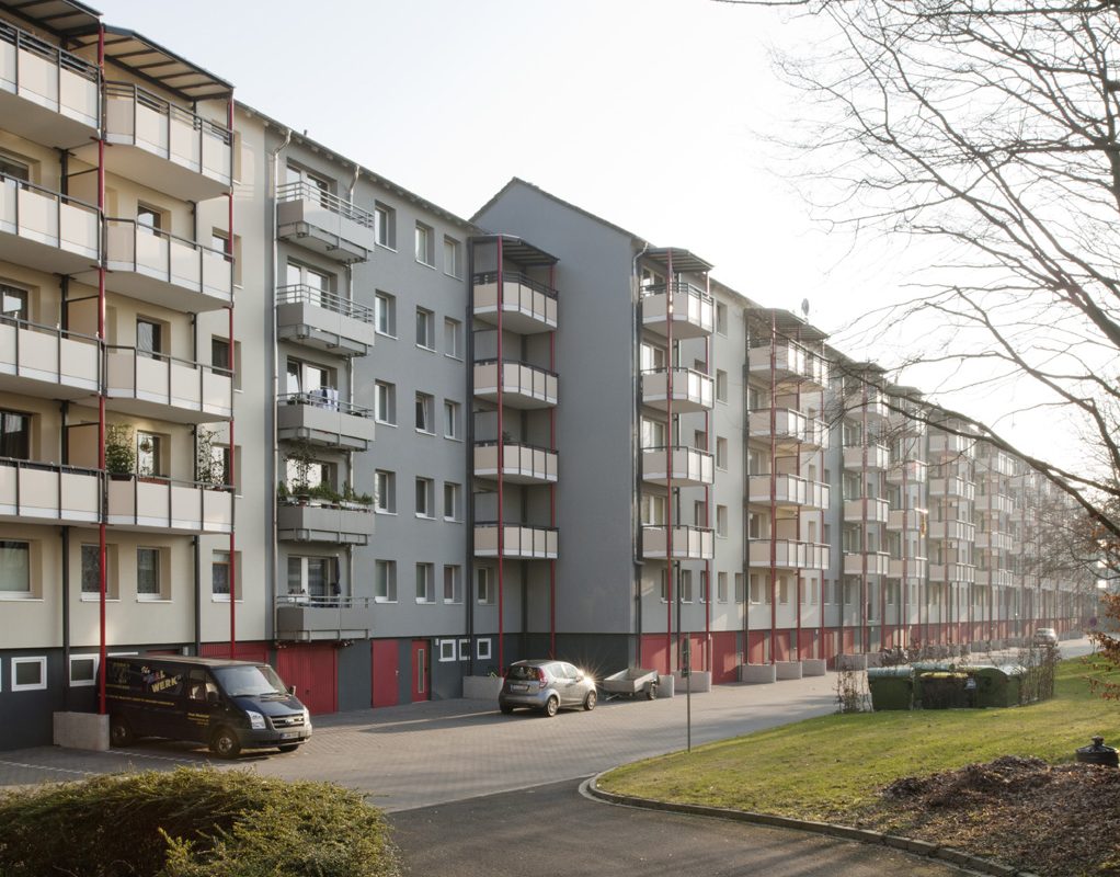 Hofseitige Balkonanlagen mit roten Rundstützen.
