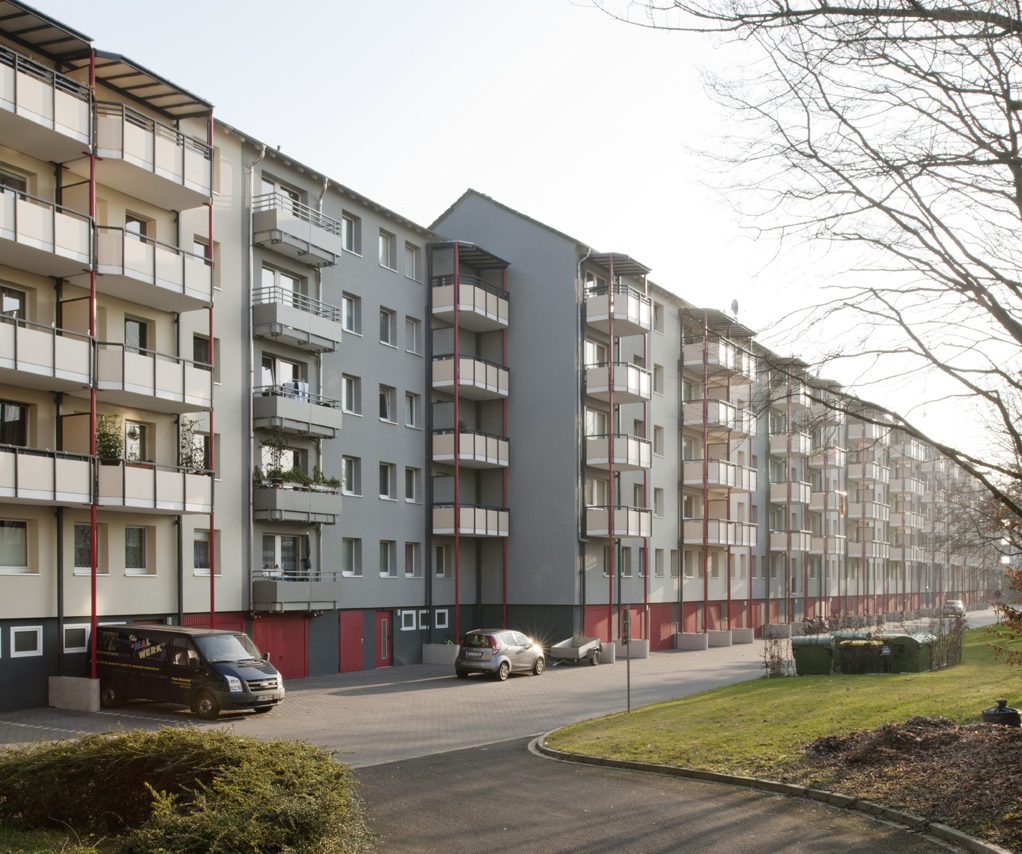 Hofseitige Balkonanlagen mit roten Rundstützen.