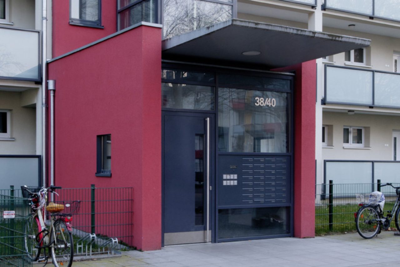 Neuer Glasaufzug vor Bestandstreppenhaus.