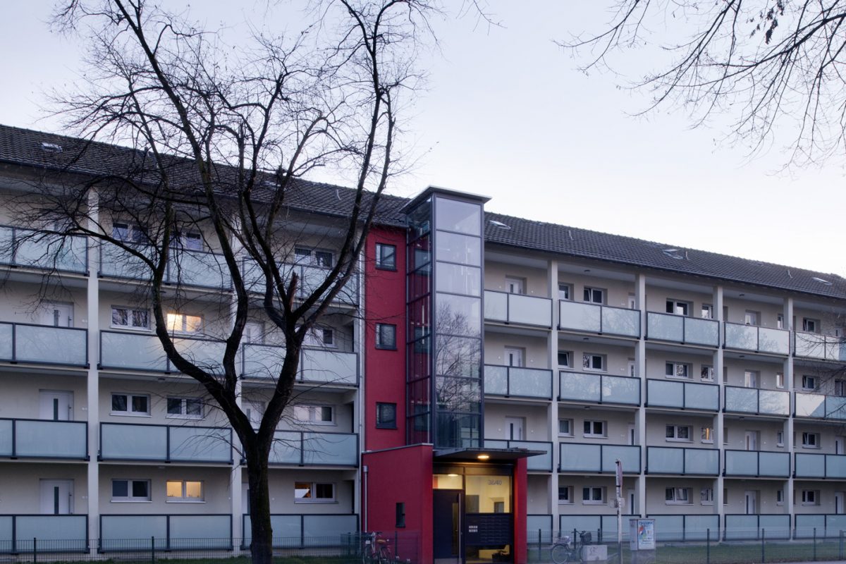 Wohnhaus mit durchgehenden Laubengängen und neuem Glasaufzug am Bestandstreppenhaus.