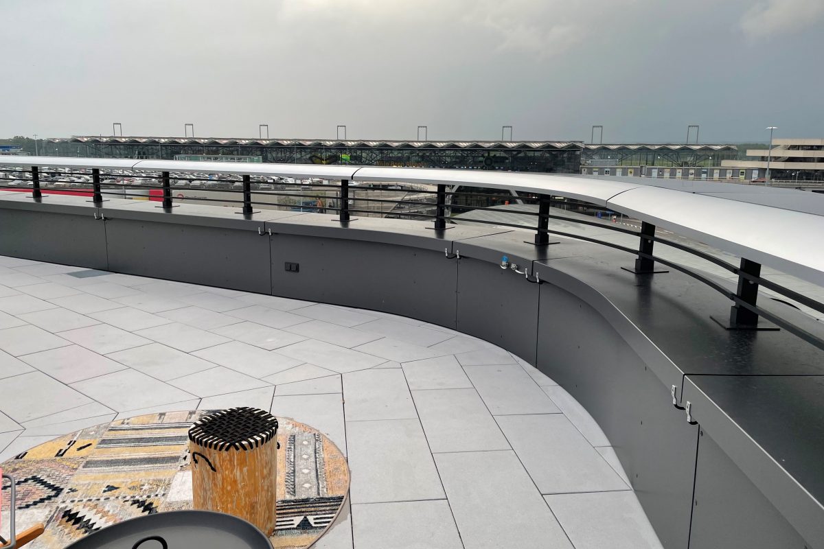 Große Dachterrasse mit Rundgeländer, Blick auf Parkdeck und Terminal.