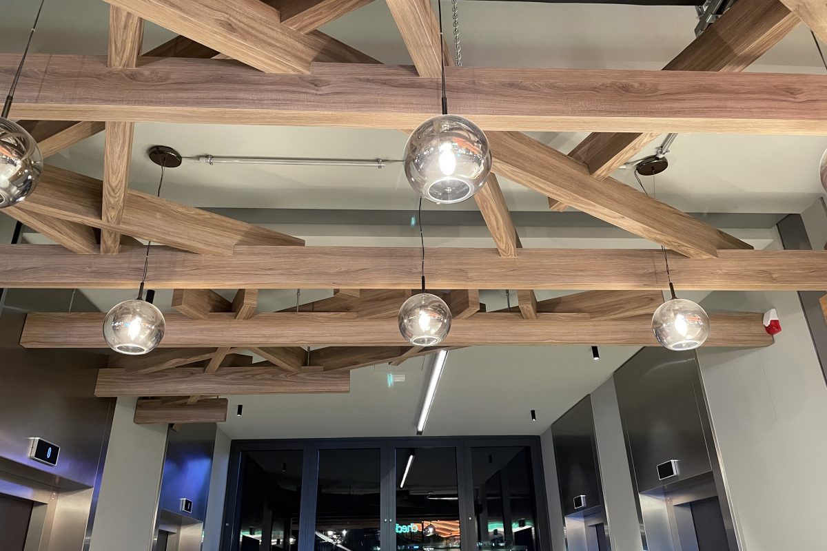 Dekorative Holzdecke mit freiliegenden Balken und kugelförmigen Hängelampen.