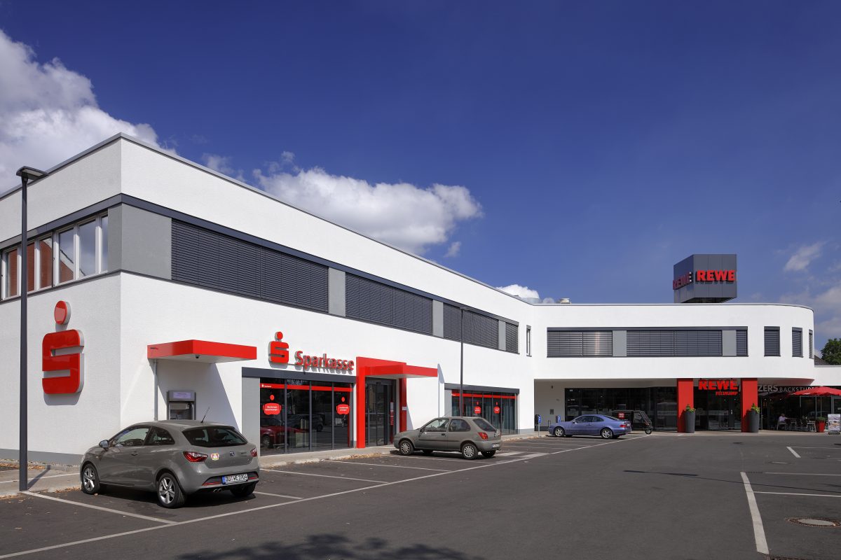 Modernes Sparkassengebäude mit Parkplatz und klarer Architektur.