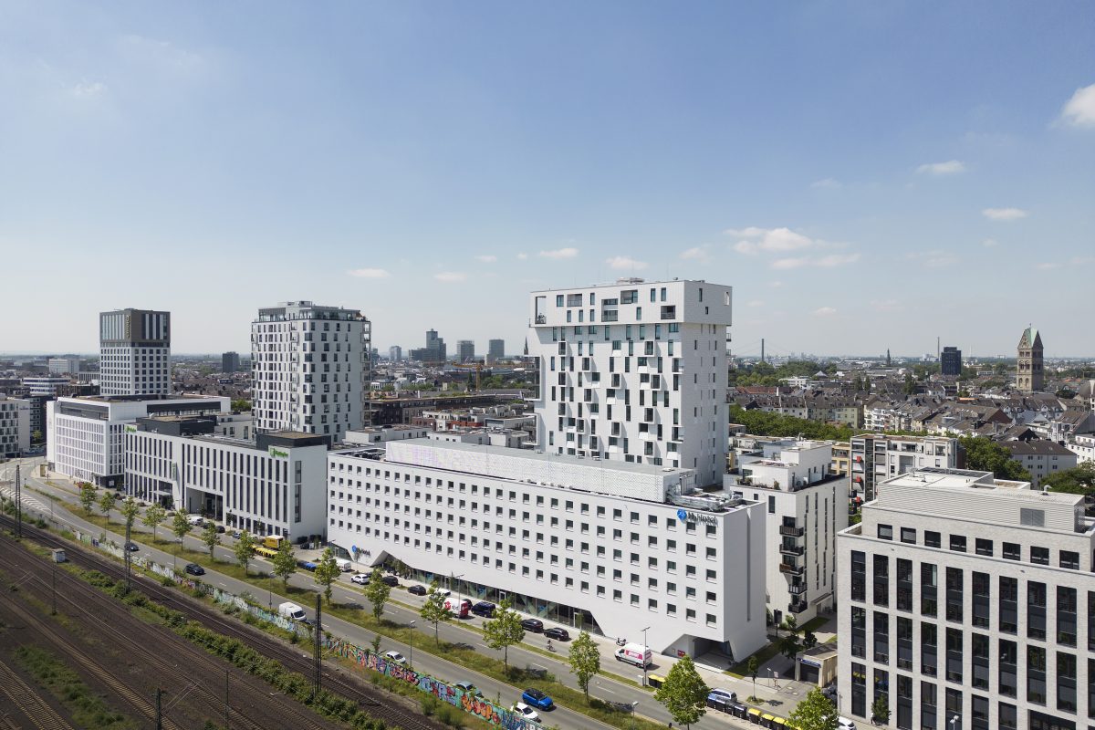 Modernes Hochhaus-Ensemble mit markanter Fassade in urbaner Umgebung.
