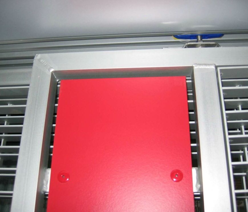 Detailaufnahme einer Fassade mit rotem Paneel und Aluminiumrahmen.