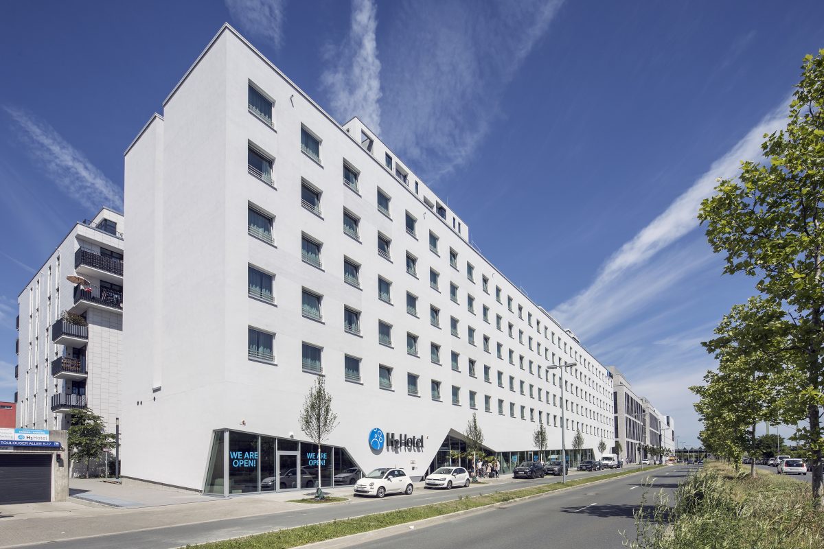 Modernes Hotelgebäude mit klarer weißer Fassade und großer Fensterreihe.