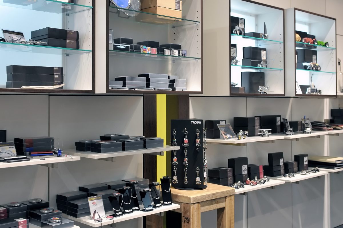 Geschenkartikel wie Uhren, Schmuck und Schlüsselanhänger im Regal.