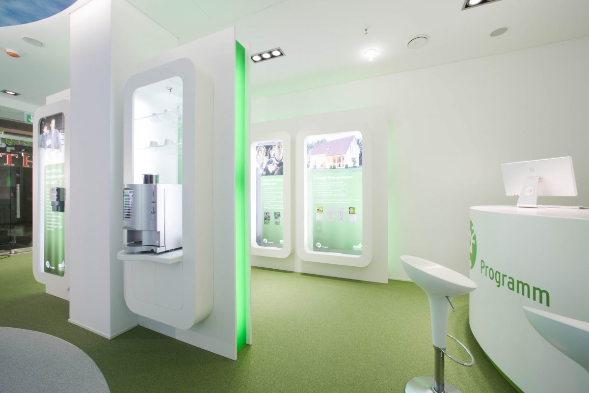 Modern gestalteter Beratungsraum mit grünen Akzenten und Infotafeln