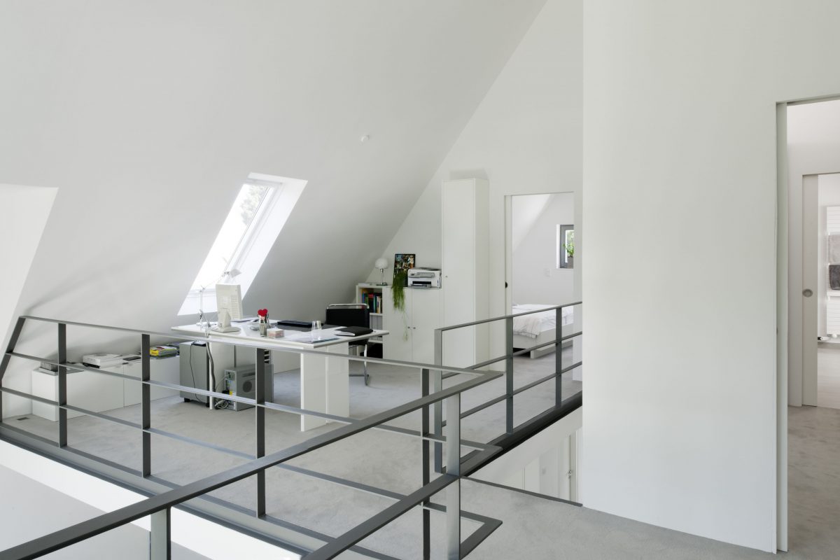 Helles Dachgeschossbüro mit Schreibtisch und Dachfenster.