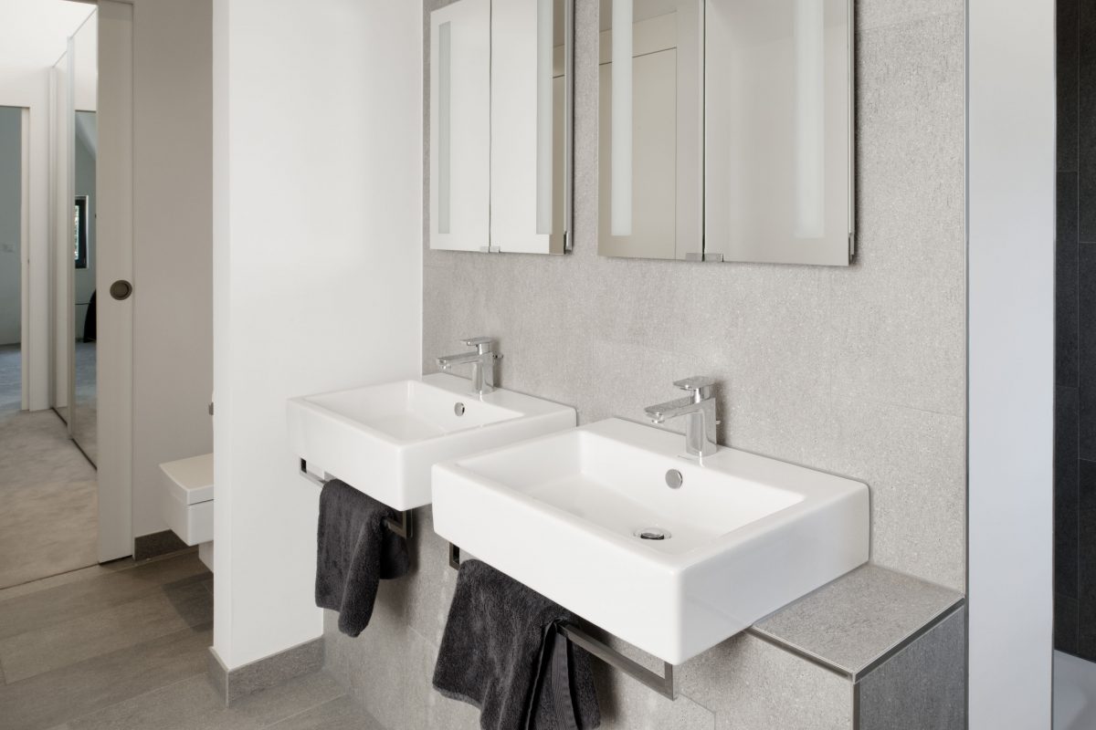 Modernes Bad mit zwei Waschbecken, Spiegeln und grauen Handtüchern