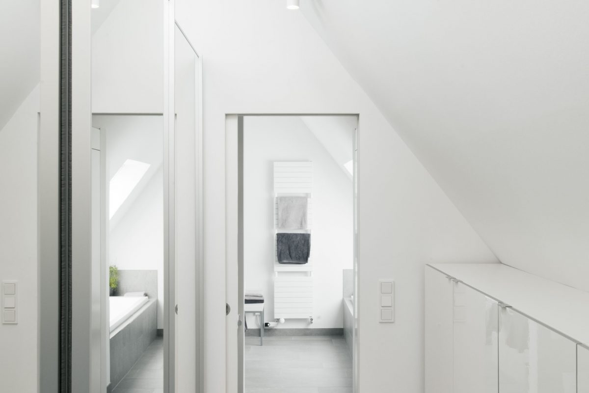 Heller Dachgeschossflur mit Einbauschränken und Blick ins Badezimmer