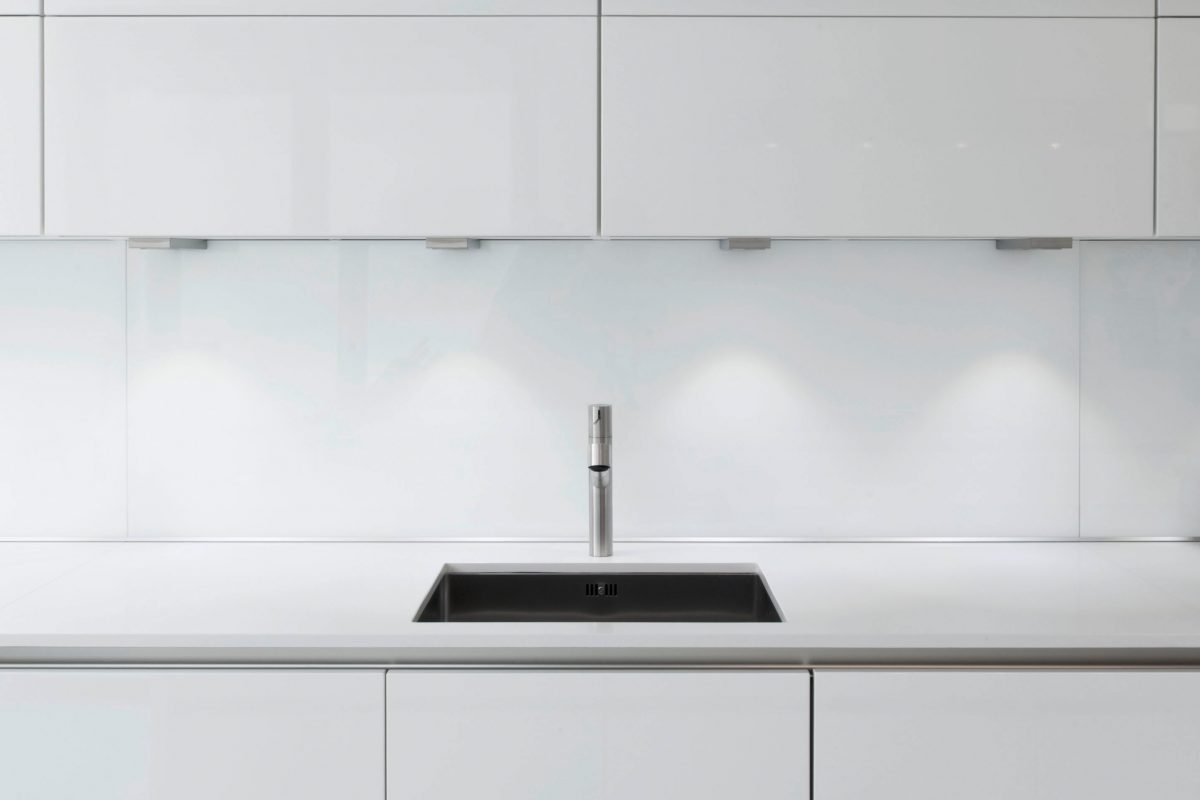 Minimalistische Küchenzeile mit weißer Front und Edelstahlspüle