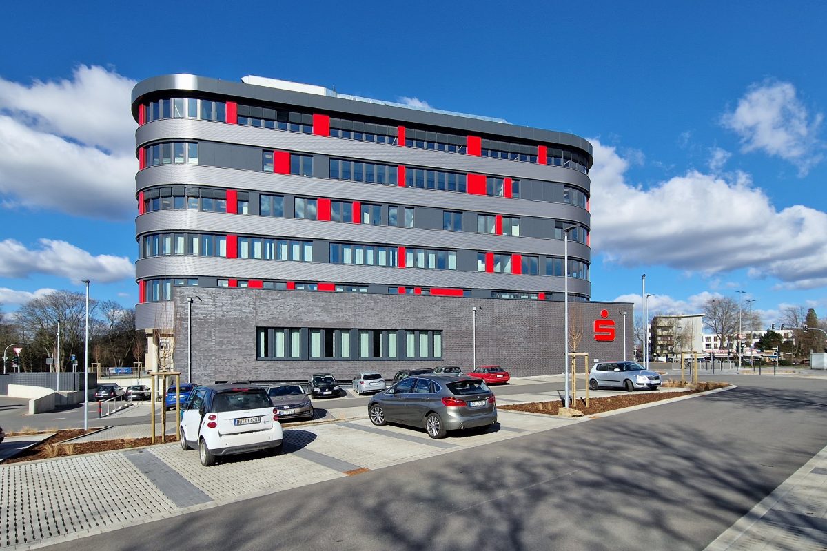 Fertiggestelltes Bürogebäude vom Parkplatz aus betrachtet