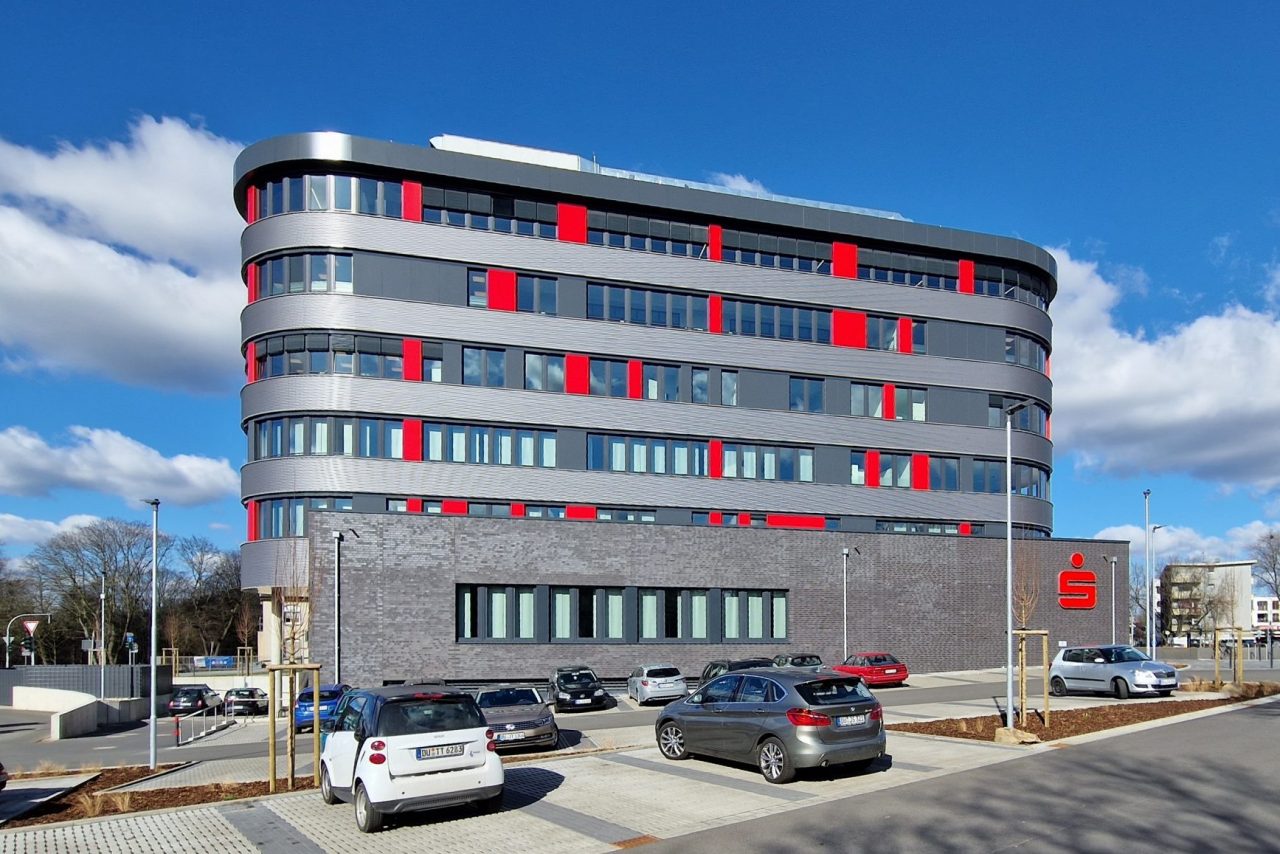 Fertiggestelltes Bürogebäude vom Parkplatz aus betrachtet